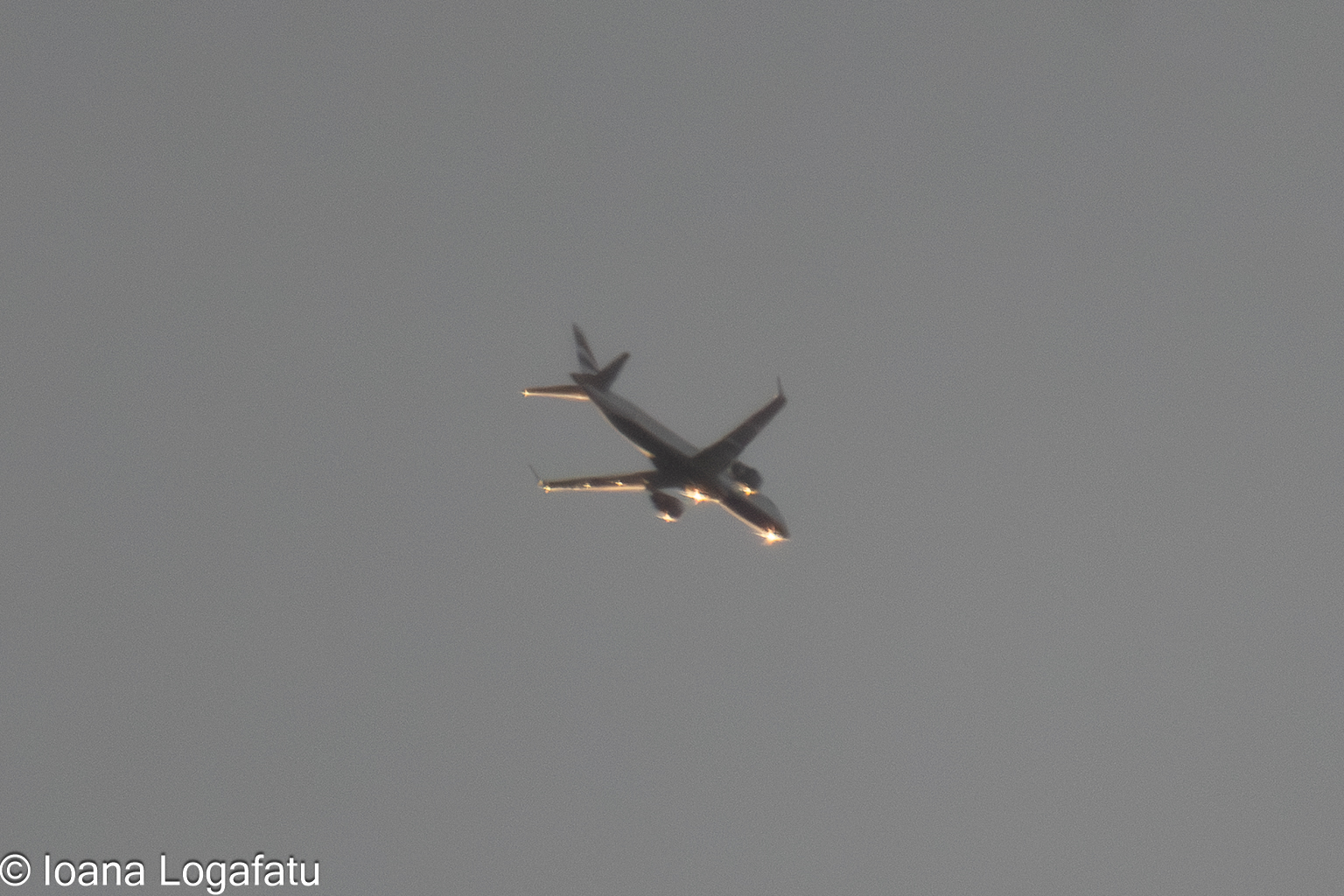 Cloudy skies above a distant airplane flying high